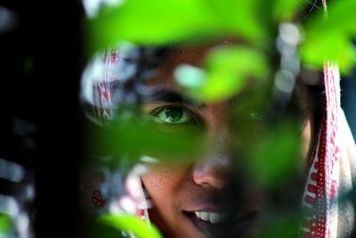 Close-up of woman seen through plant