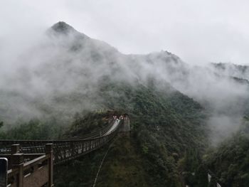 Bridge over mountain against sky