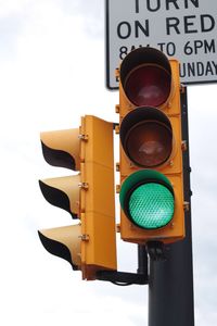 Low angle view of stoplight against sky