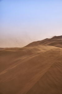 Scenic view of desert against sky during sunset