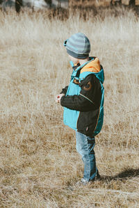 Side view of boy standing on grassy field