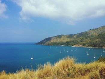 Scenic view of calm sea with mountain range in background