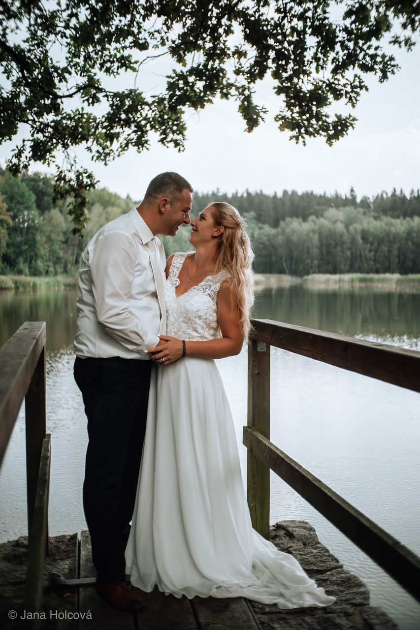 real people, two people, togetherness, tree, love, women, plant, wedding, bride, newlywed, bonding, water, lake, standing, wedding dress, couple - relationship, connection, emotion, lifestyles, adult, positive emotion, care