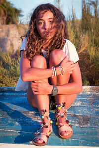 Portrait of girl sitting on wood