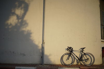 Bicycle leaning against wall of building