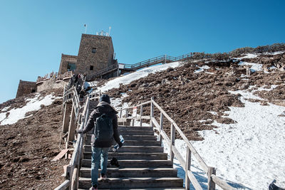 Low angle view of staircase by building against sky during winter