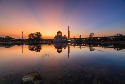 Reflection of building in lake during sunset