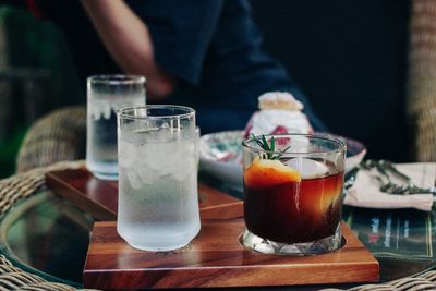 Midsection of man with drink on table