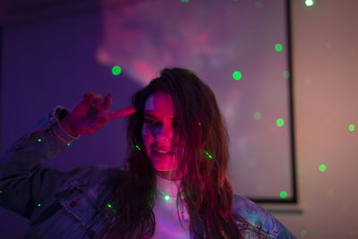 Portrait of woman against illuminated lights