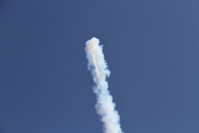Low angle view of vapor trail against clear blue sky