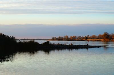 Scenic view of lake against sky at sunset