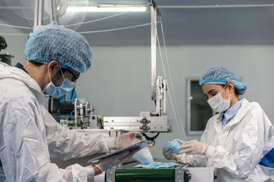 Staff and workers at the mask factory are monitoring the operation of the machines.