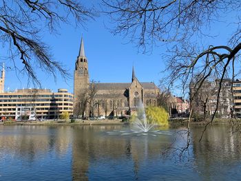 View of buildings by river against clear sky