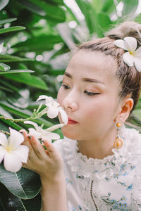 Close-up portrait of woman with pink flower