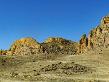 Rock formations in desert against clear blue sky