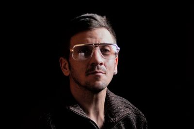 Portrait of young man against black background