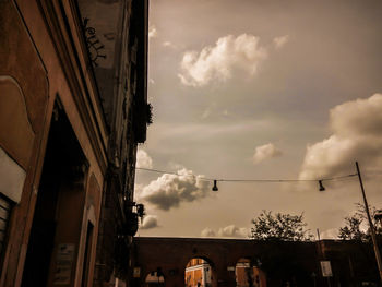 Low angle view of buildings against cloudy sky