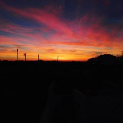 Silhouette landscape against dramatic sky during sunset