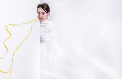 Portrait of woman standing against white background