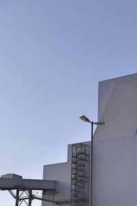 Street light by building against clear sky