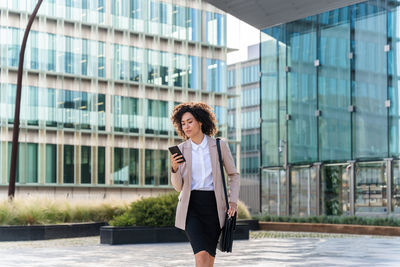 Portrait of young woman standing in city