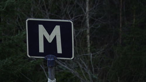 Close-up of road sign against trees