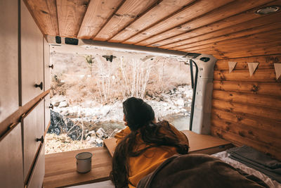 Rear view of man sitting in snow