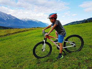 Boy riding bicycle on field