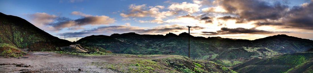 Panoramic view of land and mountains against sky during sunset