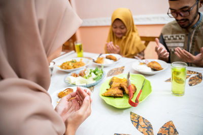 Woman praying during iftar at home