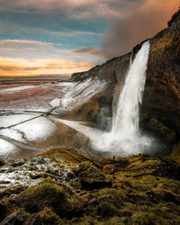 Scenic view of waterfall against sky