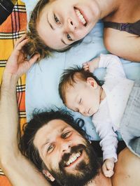 High angle view of daughter sleeping by father and mother