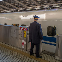 Rear view of man standing indoors