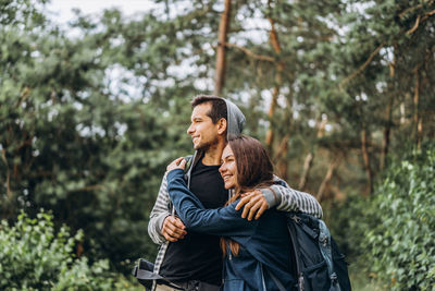 Young couple kissing against trees