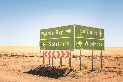 Information sign in desert against clear sky