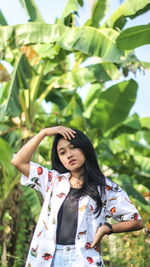 Portrait of woman standing against plants