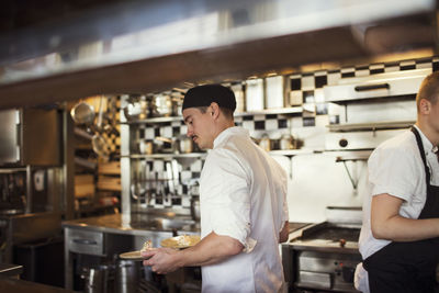 Waiter holding plates at restaurant