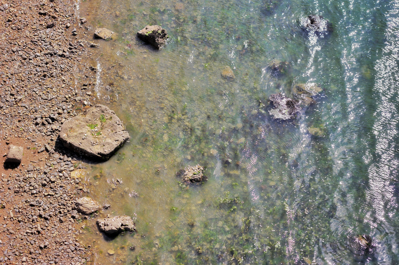 HIGH ANGLE VIEW OF ROCK IN LAKE