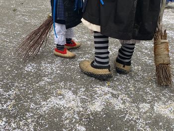 Low section of mother and daughter standing on street