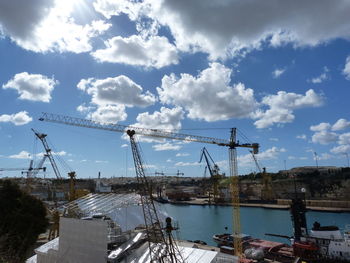 Cranes at construction site against sky