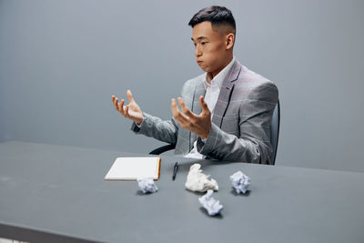 Side view of businessman using digital tablet while sitting on table