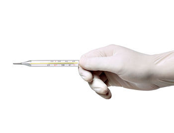 Close-up of hand holding metal against white background