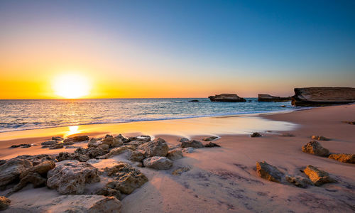 Scenic view of beach against sky during sunset