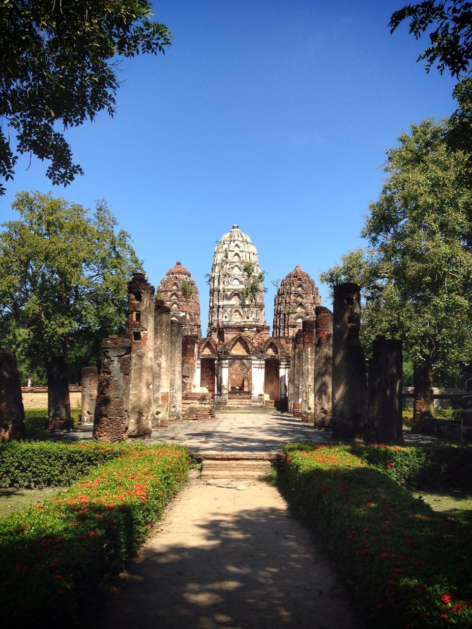 clear sky, architecture, built structure, religion, building exterior, place of worship, tree, spirituality, grass, blue, history, famous place, travel destinations, church, sunlight, copy space, travel, tourism, the way forward