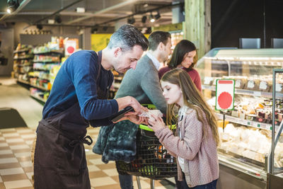 Sales clerk assisting girl in shopping at store