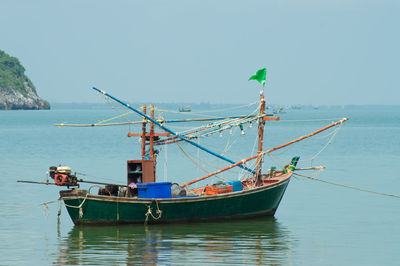 Fishing boat moored in sea against clear sky