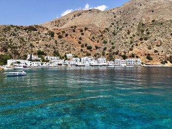 Scenic view of sea by buildings against sky