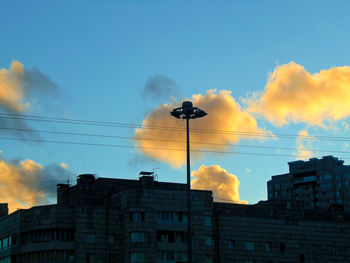 Low angle view of buildings against cloudy sky