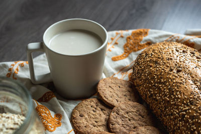 Top view of breakfast with bread, milk, cookies and oatmeal.