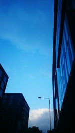 Low angle view of modern building against blue sky